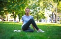 Young woman in city park on green grass doing stretching fitness exercises outdoors Royalty Free Stock Photo