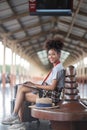 Young woman girl female sitting use computer laptop and travel bag suit case on the floor at station Royalty Free Stock Photo