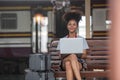 Young woman girl female sitting use computer laptop and travel bag suit case on the floor at station Royalty Free Stock Photo