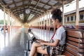 Young woman girl female sitting use computer laptop and travel bag suit case on the floor at station Royalty Free Stock Photo