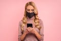 Young woman in girl in pink blouse, face mask to safe from coronavirus virus covid-19 during pandemic quarantine hold in hand Royalty Free Stock Photo