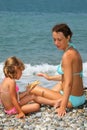 Young woman with girl played starfish on beach