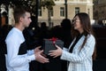 Young woman gives gift to lover. Girl gives present to friend Royalty Free Stock Photo