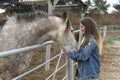 Young woman giving affection to some horses.