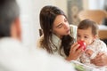 Young woman giving apple to her baby son at home Royalty Free Stock Photo