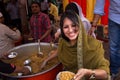 Young woman giving away rice at Guru Nanak Gurpurab celebration, New Delhi, India