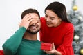 Young woman giving Christmas gift to her boyfriend Royalty Free Stock Photo