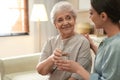 Young woman giving water to elderly lady. Senior people care