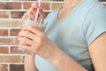 Young woman with a glass of healthy smoothie served with a straw, close-up view