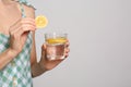 Young woman with glass of lemon water on background, closeup. Space for text Royalty Free Stock Photo