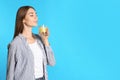 Young woman with glass of lemon water on blue background. Space for text Royalty Free Stock Photo