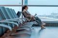 Young Woman With Glasses Reading a Book While Waiting For Boarding in Airport. Plane Wing is On Background and Blurred. Royalty Free Stock Photo