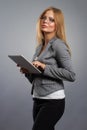 Young woman in glasses with tablet computer PC on grey background. Royalty Free Stock Photo