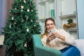 Young woman in glasses talking via mobile phone while resting in home