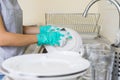 Young woman with gloves washing dishes Royalty Free Stock Photo