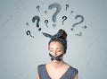 Young woman with glued mouth and question mark symbols Royalty Free Stock Photo