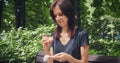 Young woman glut and can not eating burger anymore in the park sitting on bench