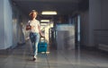 Young woman goes at airport at window with suitcase waiting for Royalty Free Stock Photo