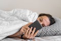 Young woman goes to sleep Phone addiction, insomnia. try to fall asleep. Sleep tracking on the phone. Circadian rhythm.