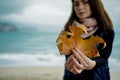 Young Woman with Gold Autumn leaf against the sea in rainy day Royalty Free Stock Photo