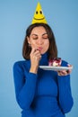 Young woman in golf on a blue background celebrates a birthday