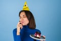 Young woman in golf on a blue background celebrates a birthday