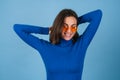 Young woman in golf on a blue background in stylish bright orange glasses