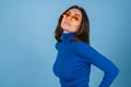 Young woman in golf on a blue background in stylish bright orange glasses