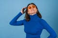Young woman in golf on a blue background in stylish bright orange glasses