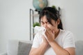 Young woman got a nose allergy sneezing sitting on the sofa at home. Flu, Influenza, Sick, Fever, Illness. Healthcare and medical