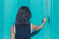 Young woman grabbing blue door