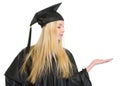 Woman in graduation gown presenting something