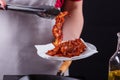 Young woman in a gray apron fries bacon Royalty Free Stock Photo