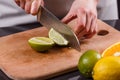 Young woman in a gray aprons cut lime Royalty Free Stock Photo
