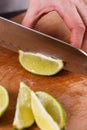 Young woman in a gray aprons cut lime Royalty Free Stock Photo
