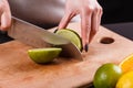 Young woman in a gray aprons cut lime Royalty Free Stock Photo