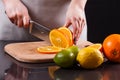 Young woman in a gray aprons cuts an orange Royalty Free Stock Photo