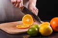 Young woman in a gray aprons cuts an orange Royalty Free Stock Photo