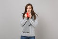 Young woman in gray sweater, scarf hold red cup of coffee or tea isolated on grey wall background in studio. Healthy Royalty Free Stock Photo