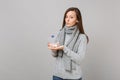 Young woman in gray sweater, scarf holding daily pill box isolated on grey wall background, studio portrait. Healthy