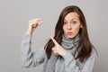 Young woman in gray sweater, scarf pointing index finger on medication tablet aspirin pill isolated on grey wall