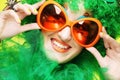 Young woman with green hair and carnaval glasses