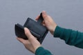 Young woman in green turtleneck holds in her hands opened large expensive wallet . Wallet made of black genuine leather. Modern Royalty Free Stock Photo