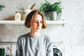 Young woman in grey dress on kitchen, scandinavian interior, slow life