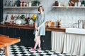 Young woman in grey dress with knitted rag bag string bag shopper in kitchen, zero waste, slow life