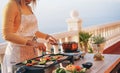 Young woman grill vegetables while preparing dinner in patio terrace outdoor - Food, healthy lifestyle and vegetarian concept - Royalty Free Stock Photo