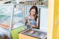 Young woman grilling a sausage and meetball