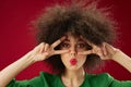 Young woman grimace afro hairstyle red lips fashion red background unaltered Royalty Free Stock Photo
