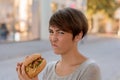 Young woman grimacing in distaste at a burger Royalty Free Stock Photo