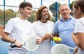 Four paddle tennis players talking on court Royalty Free Stock Photo